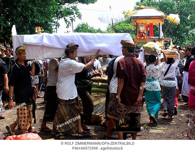 The covered body of a man is carried from the litter (BACKGROUND) to the cremation site ('pamuhunan') on the island of Bali in Sanur, Indonesia 02 February 2016
