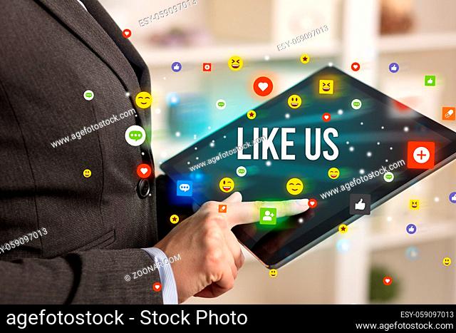 Close up of business person playing multimedia with social media icons and LIKE US inscription