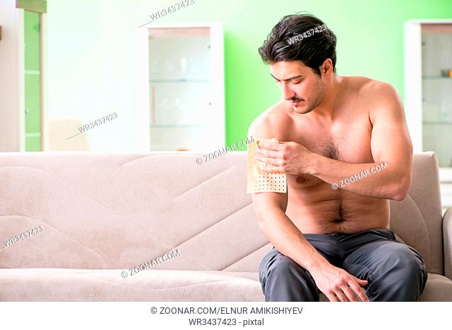 Man applying pepper Capsicum plaster to relieve pain