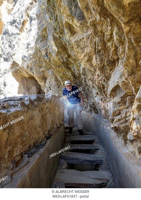 Spain, Sierra Nevada, Laujar de Andarax, senior man exploring old water canal