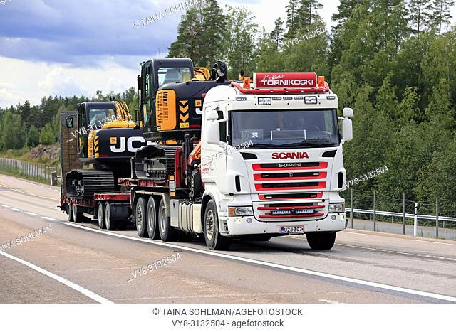 ORIVESI, FINLAND - AUGUST 27, 2018: Super Scania truck of Kuljetus Tornikoski Oy hauls two new mid-size JCB excavators along highway in late summer