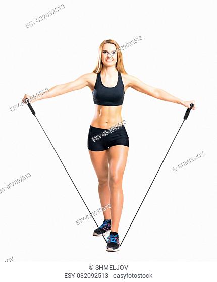 Fit, healthy and sporty woman in sportswear doing expander exercise isolated on white