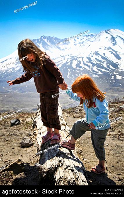 Little Girls Playing on Log in the Mountains