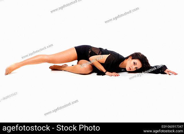 Beautiful modern dancer young woman in black flyings fabrics making dance moves. Isolated on white background. Copy space