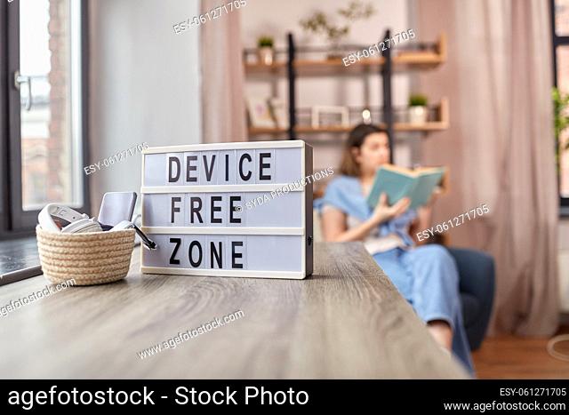 gadgets at device free zone and woman reading book