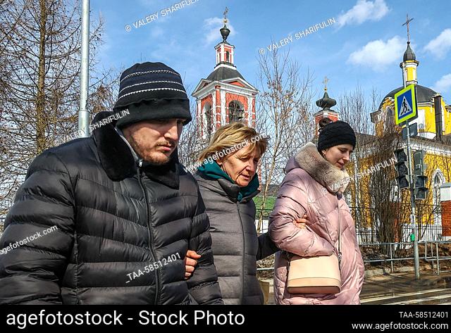 RUSSIA, MOSCOW - MARCH 23, 2023: Care recipient Sergei (L) and care recipient Nastya (R) with her mother take a walk at Special People's House (Dom Osobennykh...