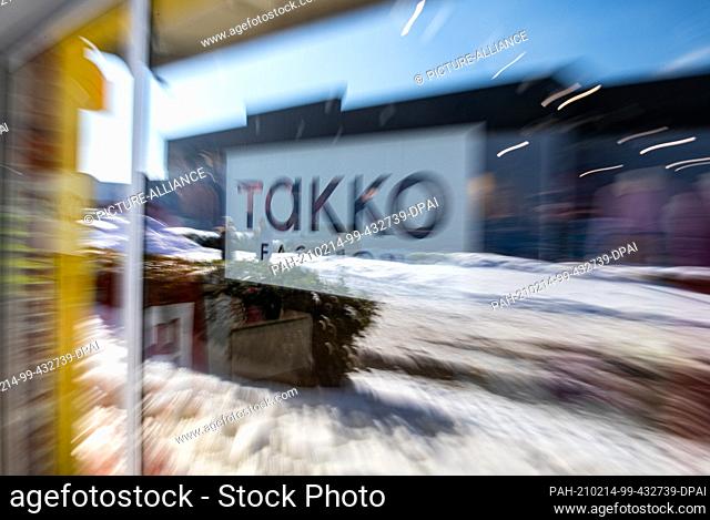 12 February 2021, North Rhine-Westphalia, Telgte: The Takko logo of a Takko Fashion store in Telgte is stuck on a glass pane