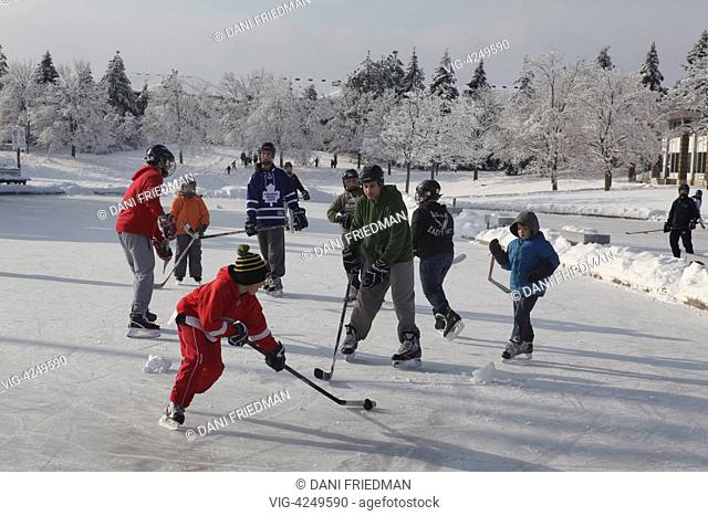 Children play a game of ice hockey on an outdoor ice rink in Ontario, Canada. Hockey is a national pastime for many Canadians who consider Canada as a Hockey...