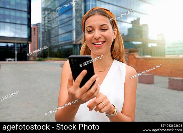 Beautiful business woman using mobile phone outdoors. People communication technology concept
