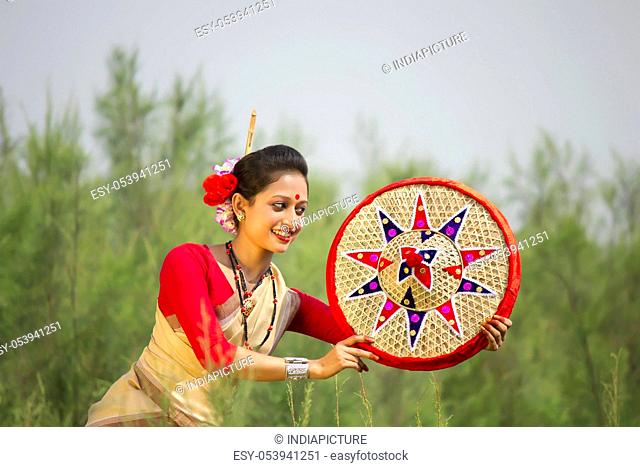 Bihu dancer holding a jaapi