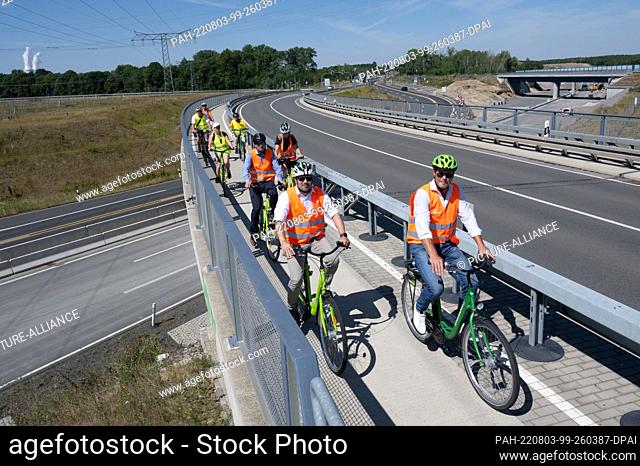 03 August 2022, Saxony, Rötha: Cyclists cross a bridge over highway 72 near Rötha. While the expansion of the last section of the A72 continues to progress