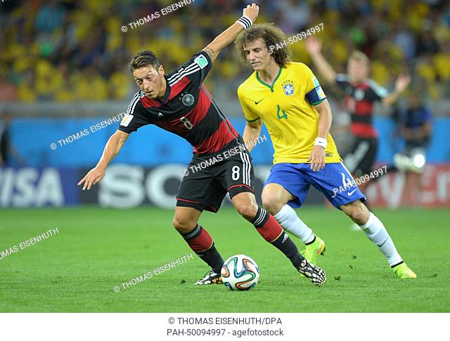 Mesut Oezil (L) of Germany and David Luiz of Brazil vie for the ball during the FIFA World Cup 2014 semi-final soccer match between Brazil and Germany at...