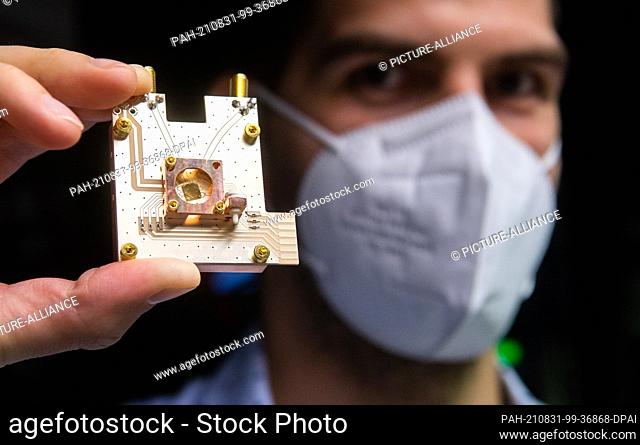 31 August 2021, Lower Saxony, Brunswick: Physicist Markus Duwe shows a quantum processor on a prototype of a quantum computer at the Physikalisch-Technische...