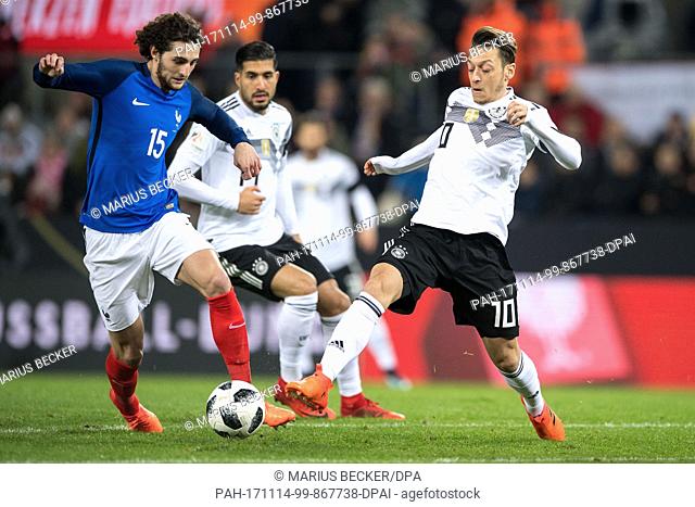Germany's Mesut Oezil (R) and France's Adrien Rabiot vie for the ball during the international soccer match between Germany and France in Cologne, Germany