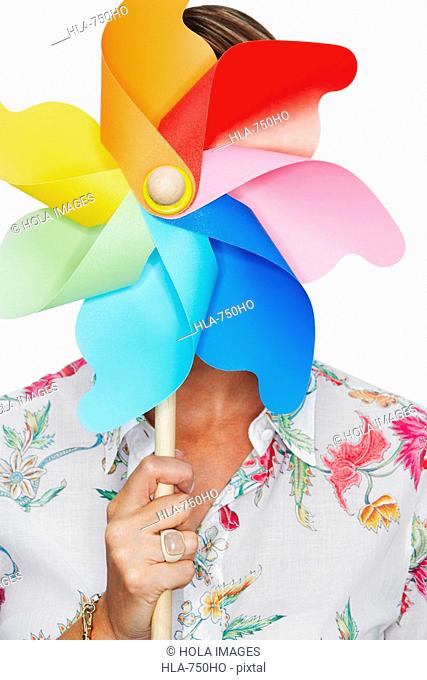 Close-up of a woman holding a pinwheel in front of her face
