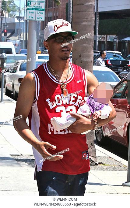 T.I., wearing a Clevland Cavaliers cap and Kobe Bryant Lower Merion basketball jersey, out for a walk with his newborn daughter on a sunny day in Beverly Hills...