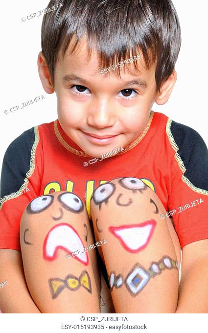 Cute little boy with painted smileys on his legs