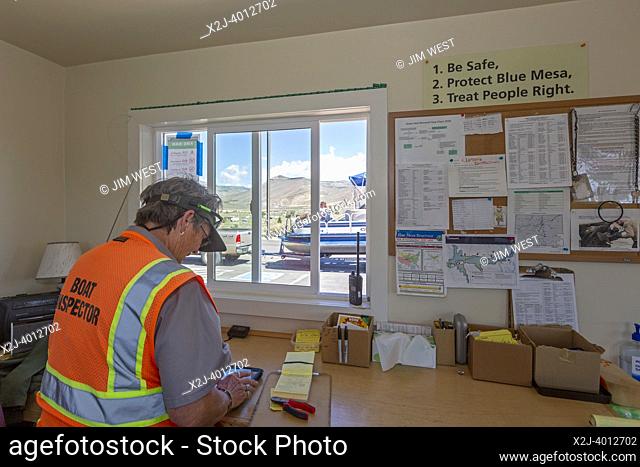 Gunnison, Colorado - Carol Soell, a boat inspector at Curecanti National Recreation Area, records information after inspecting a boat at Blue Mesa Reservoir for...