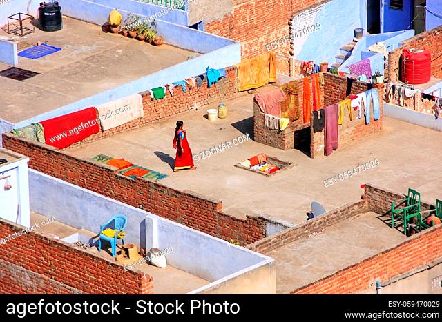 Local woman walking on a flat roof of the house in Jaipur, Rajasthan, India. Jaipur is the capital and the largest city of Rajasthan