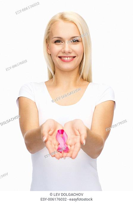 healthcare and medicine concept - smiling woman in blank t-shirt holding pink breast cancer awareness ribbon
