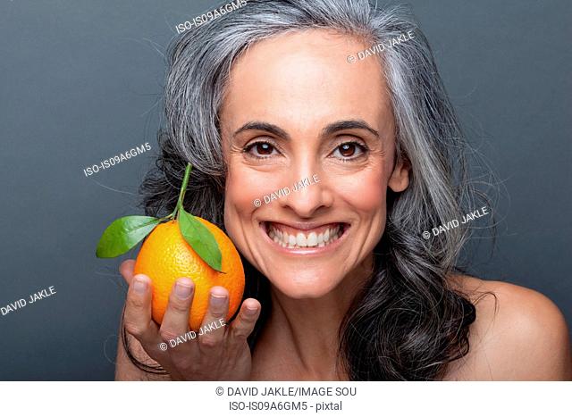 Mature woman holding orange