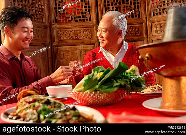 Happy father and son eat dinner drink