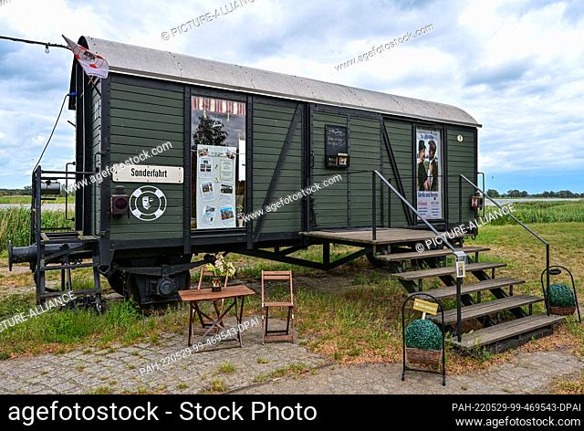 28 May 2022, Brandenburg, Groß Neuendorf: A former railroad carriage, which houses a small theater, stands at the harbor on the German-Polish border river Oder