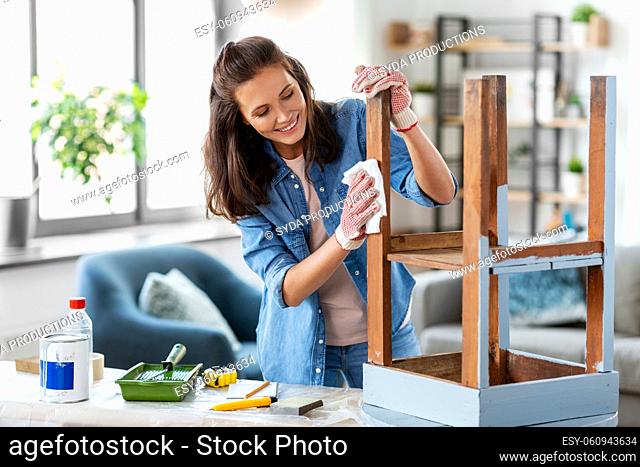 woman cleaning old table surface with tissue