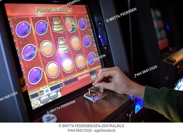 ILLUSTRATION - A young man plays around on a slot machine in a casino in Berlin, Germany, 11 March 2015. Photo: Britta Pedersen/dpa | usage worldwide