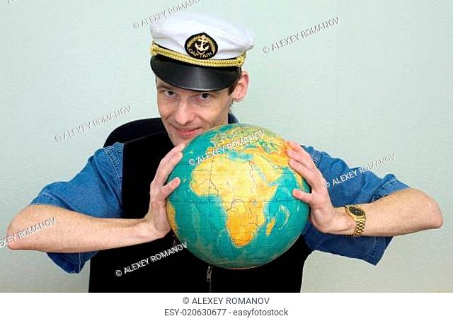 Man in a sea cap compresses globe in hands