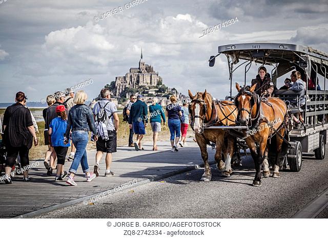 Tourists in a horse carriage near the Mont Saint Michel abbey