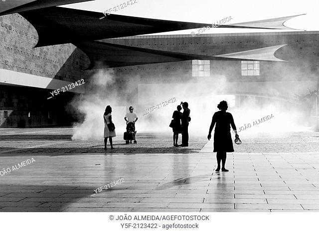 People enjoying the water vapour clouds and the shades at Centro Cultural Belém on a summer day