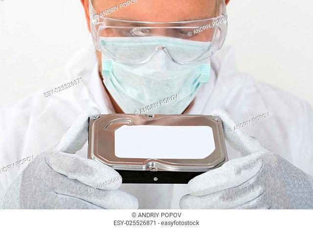 Young Man With Mask And Protective Glasses Holding Harddisk