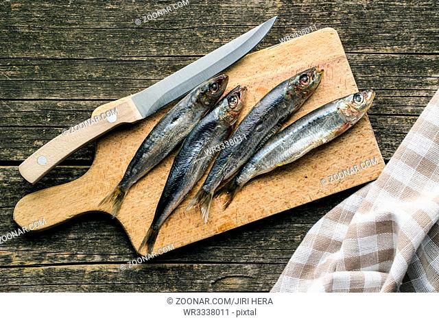 Raw sardines fish on cutting board. Top view