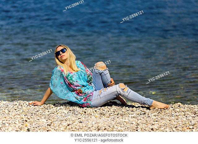 Stock Photo - Teen girl on beach barefeet in denim pants