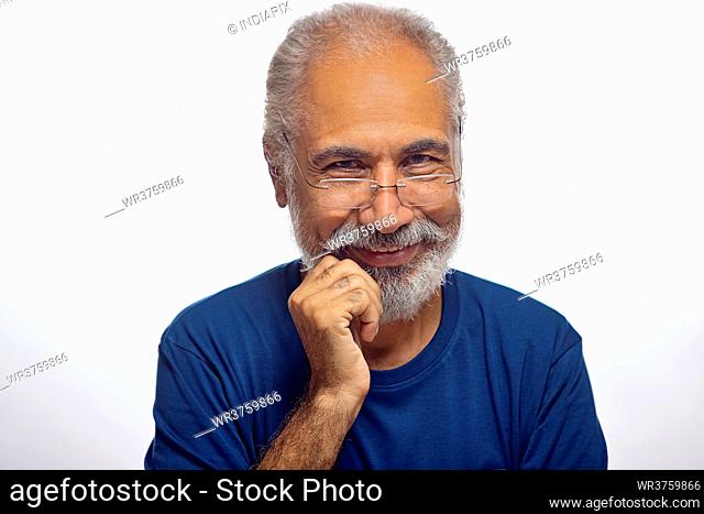 A HAPPY OLD MAN WEARING SPECS LOOKING AT CAMERA