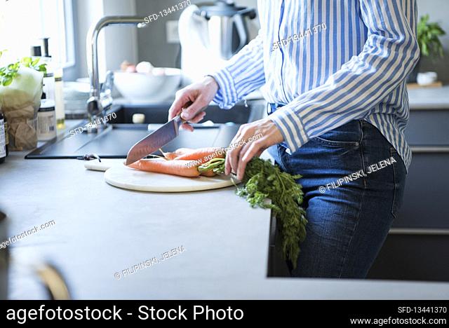 Woman cutting carrots in a kitchen