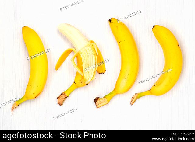 Four bananas on wooden table. Top view
