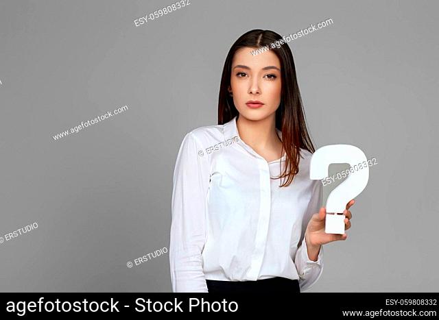 beautiful business woman with question mark on gray background