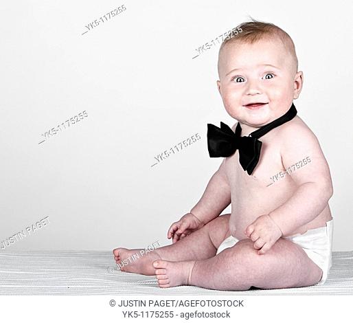 Beautiful Shot of a 5 Month Old Baby Boy in Bow Tie against Grey Background