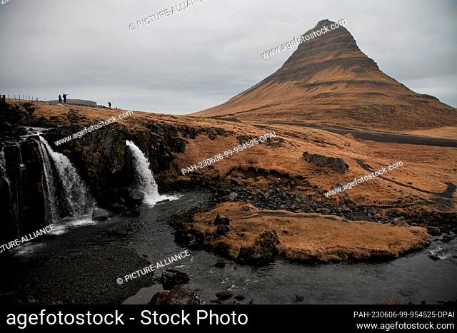 FILED - 16 April 2023, Iceland, Grundarfjördur: Kirkjufell mountain rises high on the Snæfellsnes peninsula in Iceland. In front of it you can see the...