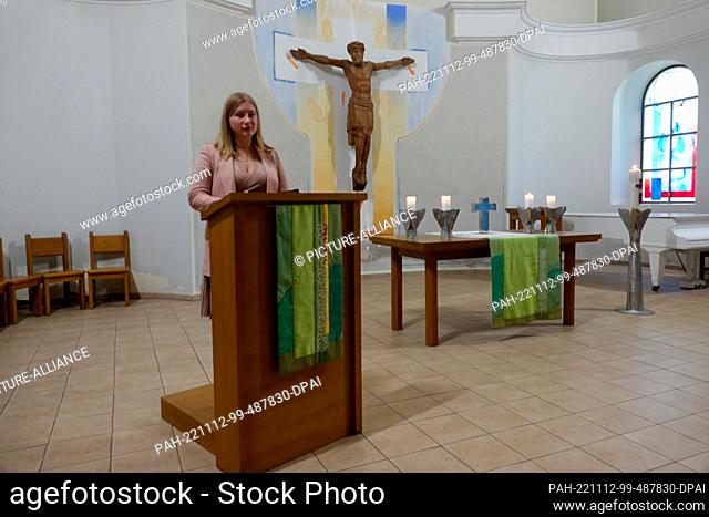 PRODUCTION - 23 October 2022, Ukraine, Kiew: Parish secretary Yelyssaveta Safronova stands at the reading desk of the German Evangelical Lutheran Church of St