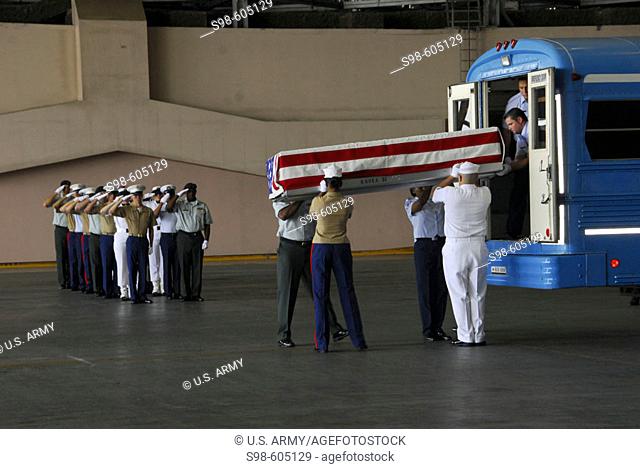 HONOLULU (April 12, 2007) - Servicemembers from Pacific Command and the Joint POW/MIA Accounting Command load a flag-draped transfer case onto a bus during a...
