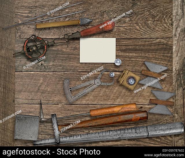 vintage jeweler tools and diamonds over wooden bench, blank card for your business