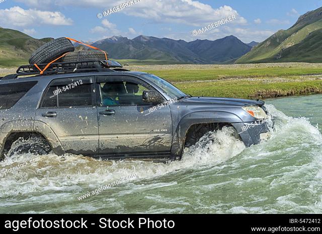 Four-wheel drive crossing a river, Kurumduk Valley, Naryn Province, Kyrgyzstan, Central Asia, Asia