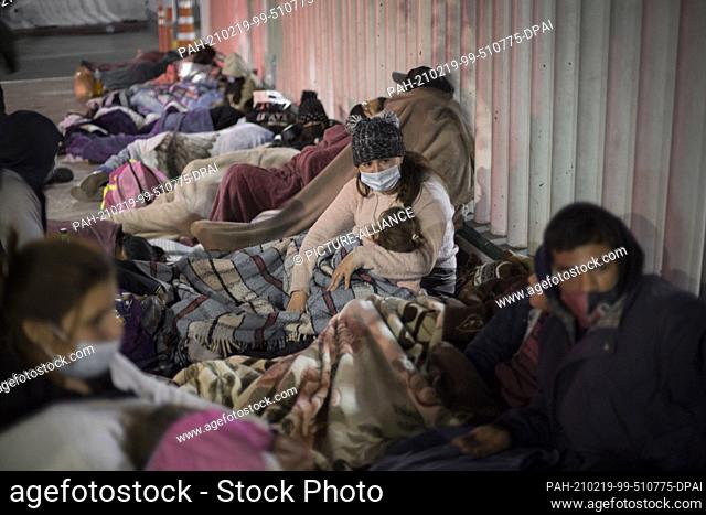 dpatop - 19 February 2021, Mexico, Tijuana: Dozens of migrants of Central American and Mexican origin sleep on the esplanade of the National Institute of...