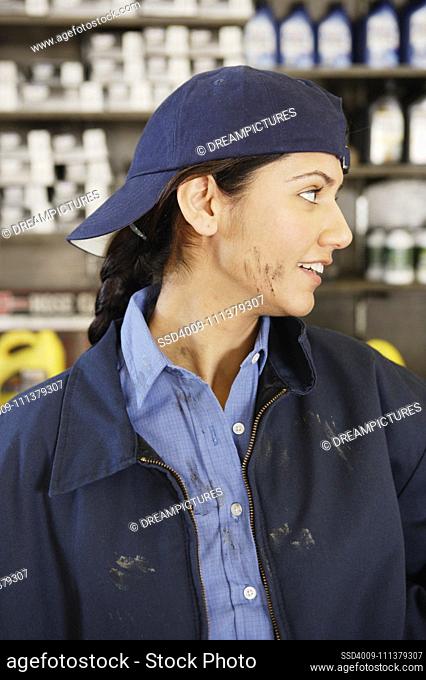Young female mechanic with oil on her face