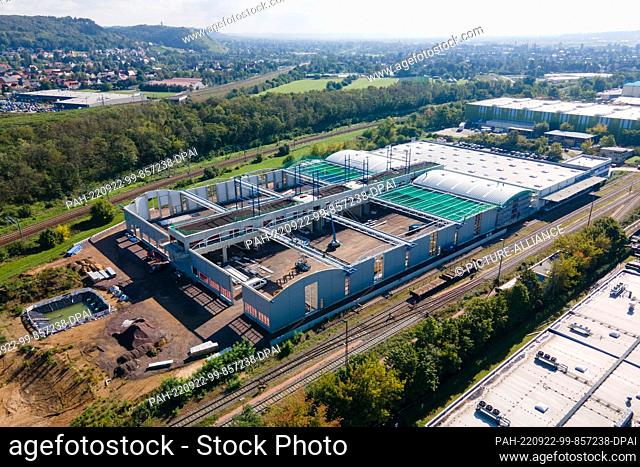 22 September 2022, Saxony, Radebeul: Construction vehicles stand on a building site for a new cardboard factory of the printing company Ellerhold (aerial view...