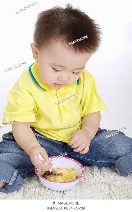 Baby boy sitting and eating, Child