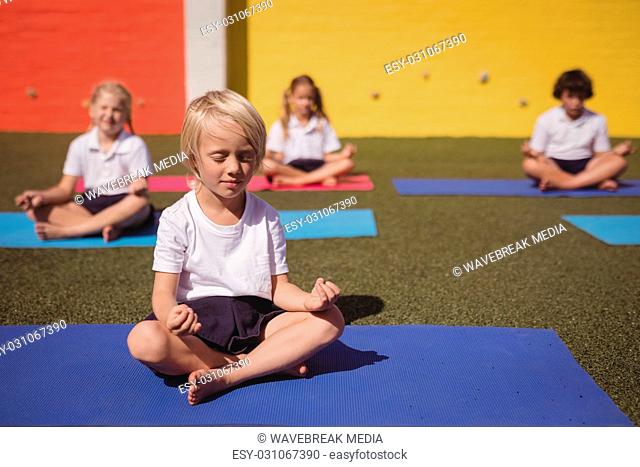 Schoolkids practicing yoga